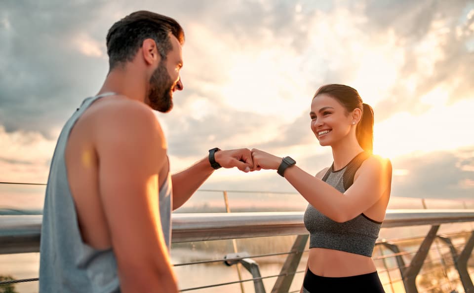 A couple walking together on a harbour front at dusk